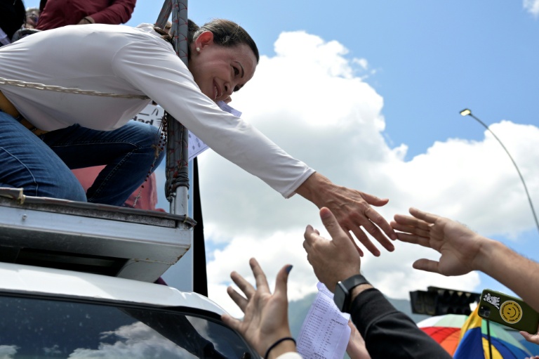 La cheffe de l'opposition au Venezuela, Maria Corina Machado (g) salue ses partisans lors d'une manifestation à Caracas, le 17 août 2024