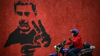 Un homme passe près d'une fresque représentant Nicolas Maduro, le 14 mai 2026 à Caracas