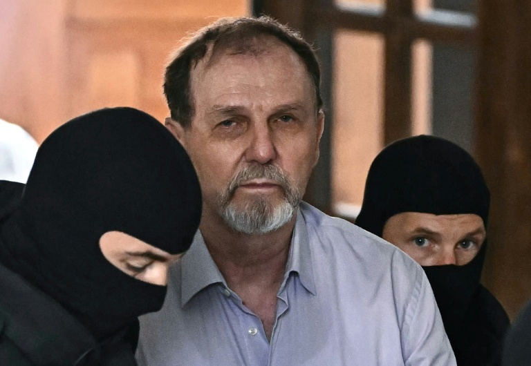 La police escorte Juraj Cintula jusqu'à la salle d'audience de Banska Bystrica, en Slovaquie, le 8 juillet 2025, pour le début de son procès où il est accusé d'avoir tiré sur le Premier ministre slovaque Robert Fico