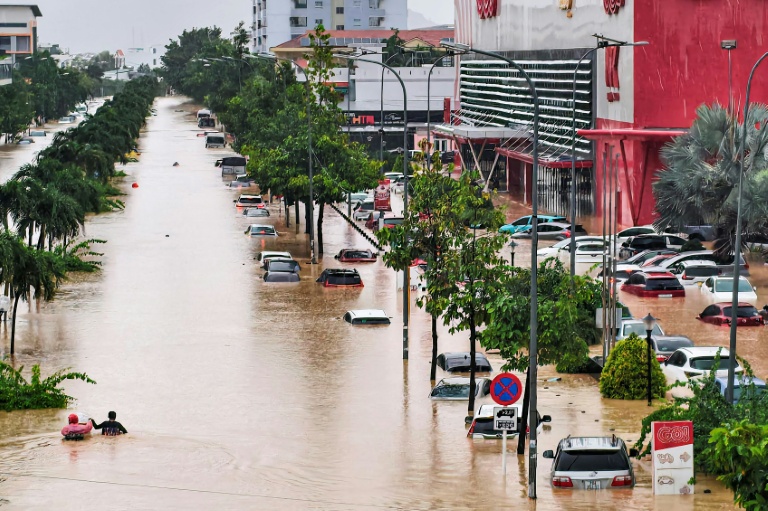 Des personnes traversent une rue inondée de Nha Trang au Vietnam le 20 novembre 2025