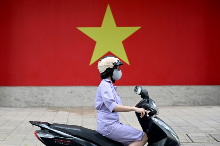 Une femme conduit un scooter à Hanoi, le 17 juillet 2025