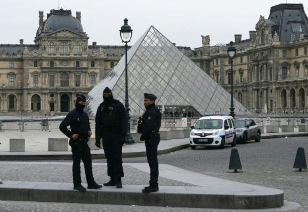 Des policiers devant le musée du Louvre, cible d'un spectaculaire cambriolage, le 19 octobre 2025 à Paris 