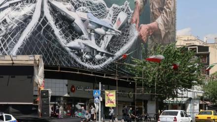 Des véhicules passent devant un immense panneau d'affichage sur lequel est écrit "Le détroit d'Ormuz reste fermé", sur la place de la Révolution à Téhéran, le 28 avril 2026, en Iran