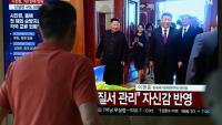 Un homme passe devant un écran de télévision diffusant un journal télévisé avec des images d'archives de la rencontre de 2019 entre le président chinois Xi Jinping et le dirigeant nord-coréen Kim Jong Un, dans une gare de Séoul, le 8 juin 2026