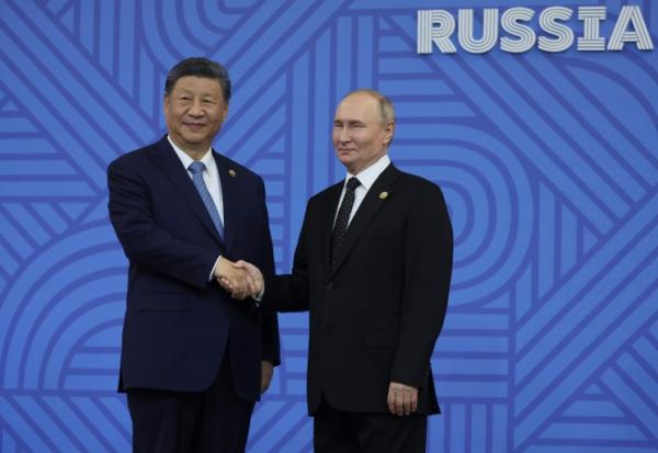 Le président russe Vladimir Poutine salue le président chinois Xi Jinping lors d'une cérémonie officielle d'accueil des chefs de délégation au sommet des BRICS à Kazan, en Russie, le 23 octobre 2024
