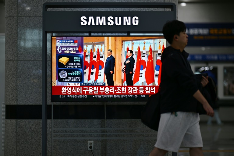 Un écran de télévision dans une gare ferroviaire de Gyeongju, le 1er novembre 2025, diffuse un journal télévisé montrant le président sud-coréen Lee Jae Myung et le président chinois Xi Jinping lors d'une cérémonie de bienvenue dans le cadre du sommet de la Coopération économique Asie-Pacifique (APEC)