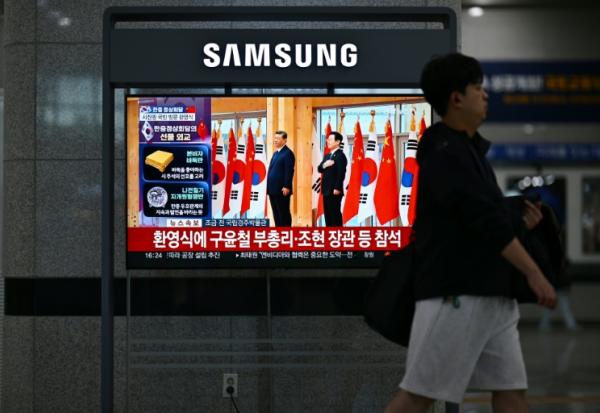 Un écran de télévision dans une gare ferroviaire de Gyeongju, le 1er novembre 2025, diffuse un journal télévisé montrant le président sud-coréen Lee Jae Myung et le président chinois Xi Jinping lors d'une cérémonie de bienvenue dans le cadre du sommet de la Coopération économique Asie-Pacifique (APEC)