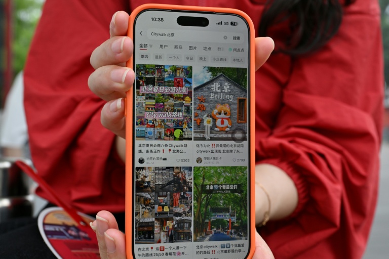 Une touriste chinoise, originaire de la province du Hunan, montre son compte Xiaohongshu sur son téléphone portable alors qu'elle visite la Cité interdite à Pékin, le 11 juillet 2026