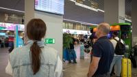 Des passagers regardent un panneau d'affichage des vols à l'aéroport de Kaliningrad, en Russie, le 4 juillet 2026