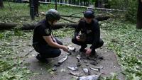 Des policiers ukrainiens examinent des fragments d'un missile dans un parc de Kharkiv le 19 mai 2024