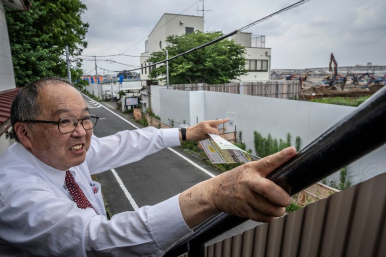 Yasuo Yamazaki, représentant d'un collectif de citoyens inquiets de la construction d'un centre de données, montre le site du projet à Hino, dans la préfecture de Tokyo, au Japon, le 30 juin 2026 