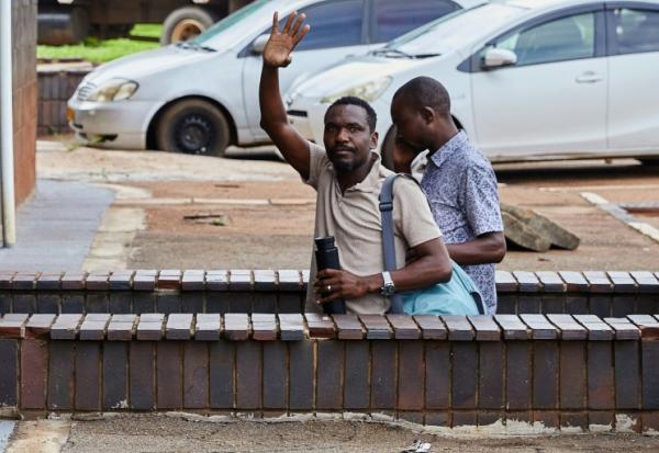 Le journaliste zimbabwéen Blessed Mhlanga adresse un salut en arrivant au tribunal à Harare le 25 février 2025